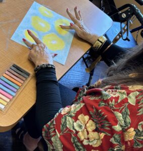 senior participant in workshop creating artwork